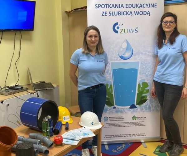 Pracownice ZUWŚ Sp. z o.o. na tle rollupa z informacją o projekcie.