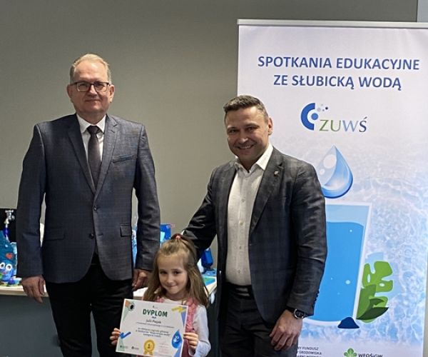 Prezes ZUWŚ i burmistrz Słubic z laureatką konkursu na tle rollupa z napisem: Spotkania ze słubicką wodą.