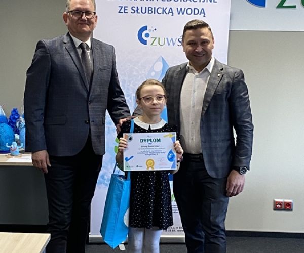 Prezes ZUWŚ i burmistrz Słubic z osobą wyróżnioną w konkursie na tle rollupa z napisem: Spotkania ze słubicką wodą.