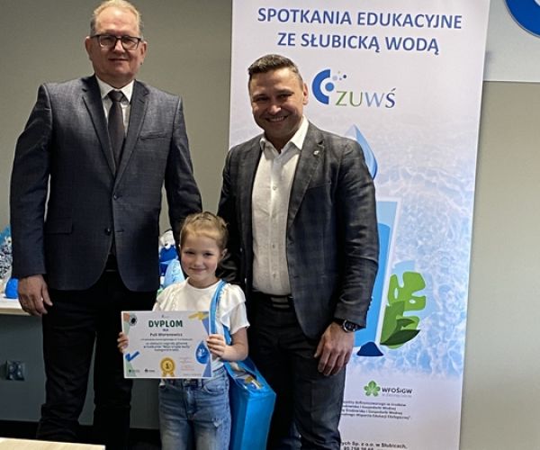 Prezes ZUWŚ i burmistrz Słubic z laureatką konkursu na tle rollupa z napisem: Spotkania ze słubicką wodą.