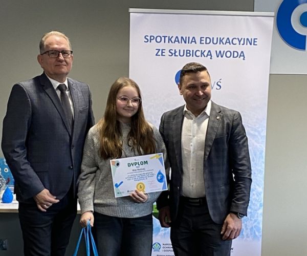 Prezes ZUWŚ i burmistrz Słubic z laurteatką konkursu na tle rollupa z napisem: Spotkania ze słubicką wodą.