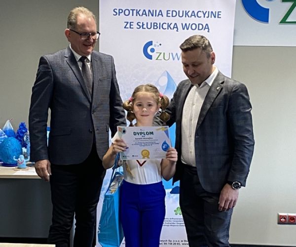 Prezes ZUWŚ i burmistrz Słubic z osobą wyróżnioną w konkursie na tle rollupa z napisem: Spotkania ze słubicką wodą.